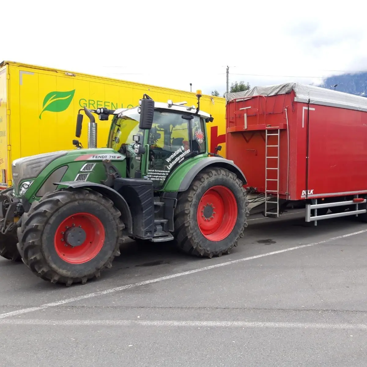 Traktor mit rotem Transportanhänger